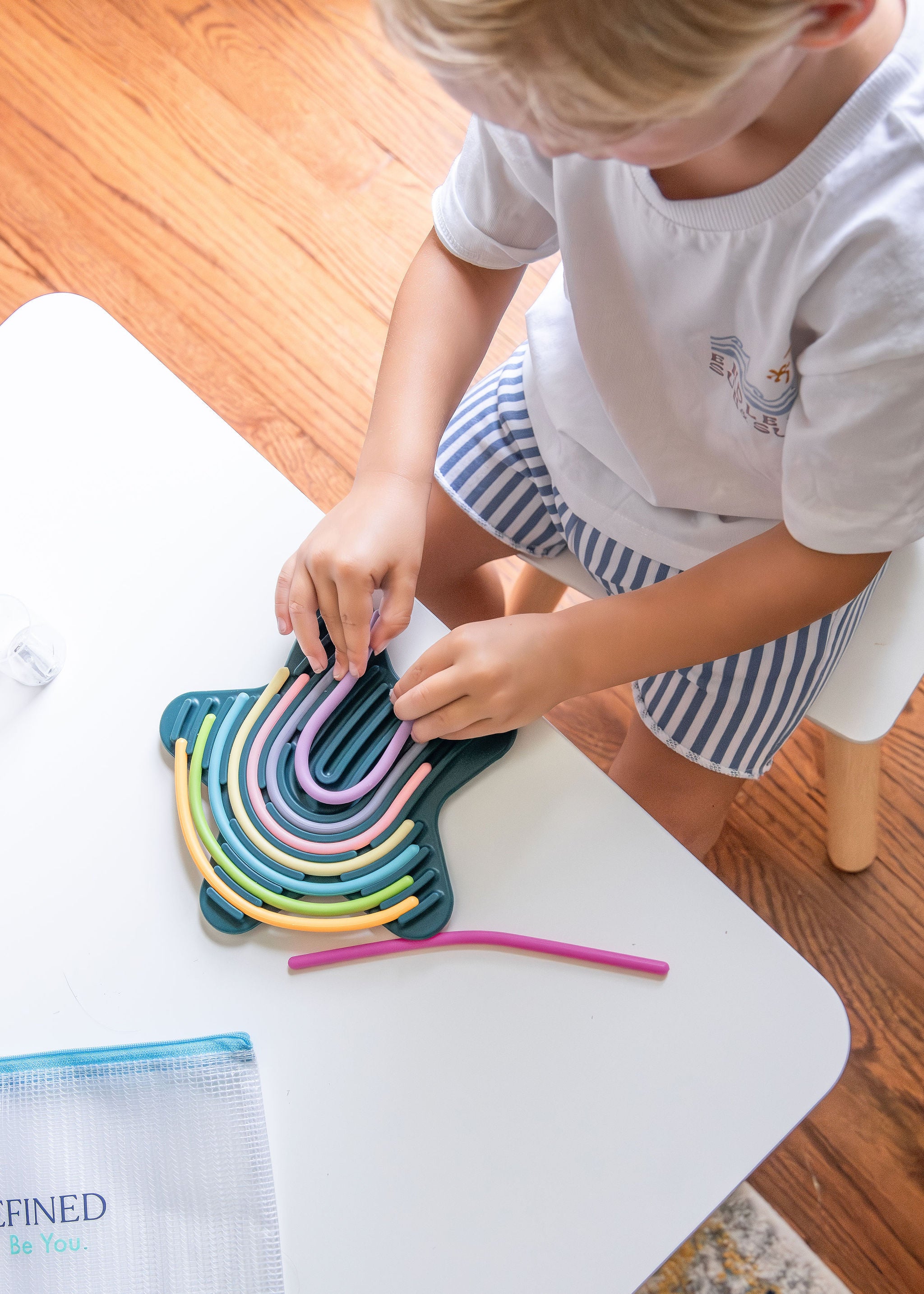 Child using silicone sensory activity board for fine motor play